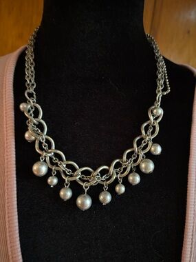 Silver-toned statement necklace featuring layered chains and dangling pearls